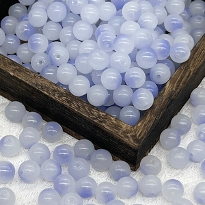 Detailed close-up of 8mm gradient purple glass beads in a dark wooden jewelry tray