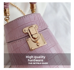 Detail of lavender crocodile-embossed bucket bag with elegant gold metal twist-lock buckle