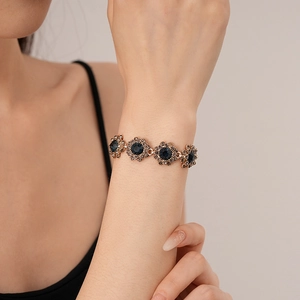 Macro view of vintage flower bracelet with blue center stones and sparkling rhinestones