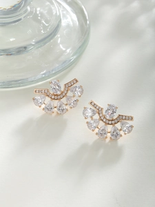 Detailed close-up of fan-shaped gold earrings with zircon crystals and vintage court style