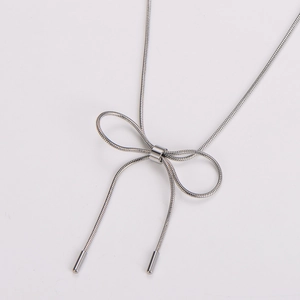Detail of silver snake chain necklace showing bow knot design and metallic texture