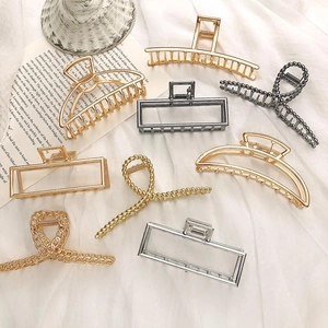 French style metal hair claw clips in gold and silver set on white fabric
