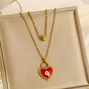 Gold double-layered necklace featuring a red heart pendant with an evil eye motif