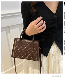 Sac bandoulière marron matelassé avec détail cœur et poignée porté par un mannequin