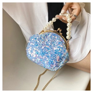 Detail of blue sequin shell bag featuring pearl handle and golden chain strap