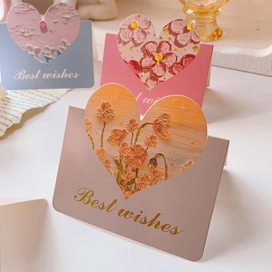 Detail of 3D heart-shaped greeting cards with floral patterns and gold Best wishes text