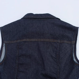 Detailweergave van de achterkant van een donkerblauw denim vest met klassieke oranje stiksels