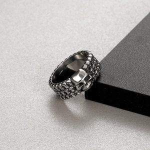Close-up of gothic stainless steel ring featuring vintage skull reliefs and dark finish