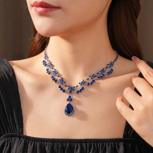 Detail of a luxury silver necklace with blue zircon flowers and pear-shaped drop pendant