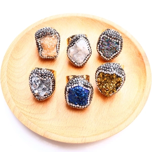 Macro detail of six colorful natural druzy crystal rings with rhinestone pavé edges