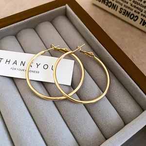 Elegant gold minimalist hoop earrings with shimmering diamonds on a velvet jewelry box