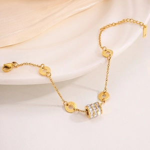 Golden stainless steel bracelet featuring Roman numeral rings and zircon cylinder pendant