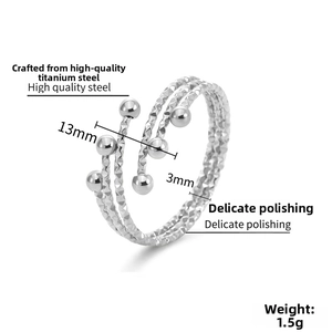 Macro detail of triple-layer spiral stainless steel ring with textured finish and beads