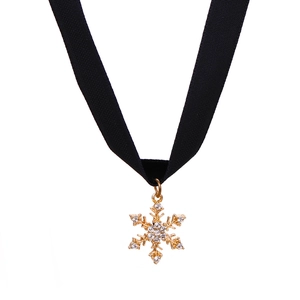 Detail of black velvet choker with a gold snowflake pendant and sparkling crystals