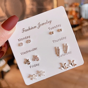 Detail of 6-pair silver earring set with floral and star shapes on a weekly mood display card