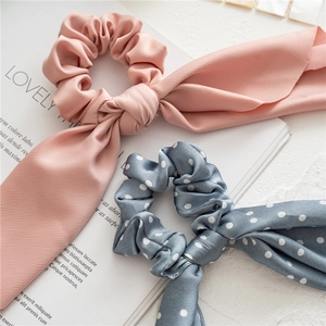 Detail of floral and solid long ribbon scrunchies on a minimalist background