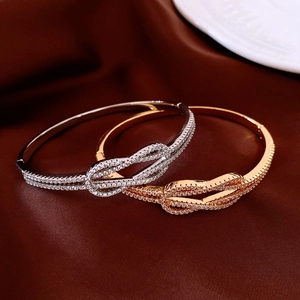 Détail de bracelets à nœuds torsadés en or et argent avec zircons étincelants