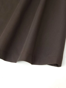 Detail view of the deep brown maxi dress hemline with high-quality stitching and fabric texture