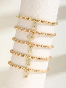 Detail view of 26 alphabet bead bracelets with gold plating and sparkling letter charms