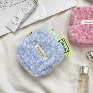 Detalle de bolsas de felpa suave con estampado de leopardo en azul y rosa con marca