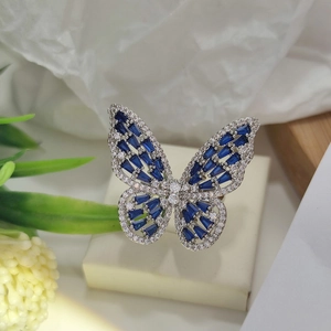 Detailed shot of silver butterfly ring featuring deep blue rectangular gemstones and crystals