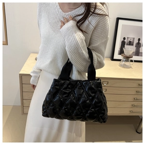Minimalist black quilted puffer tote bag shown on a model for a casual commute look