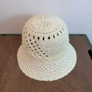 Top view of beige hollow crochet bucket hat with intricate woven diamond patterns