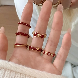 Detail of 6-piece vintage gold and burgundy enamel ring set with star and flower motifs