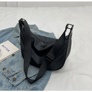 Detailed close-up of a black nylon hobo dumpling bag with an adjustable wide shoulder strap