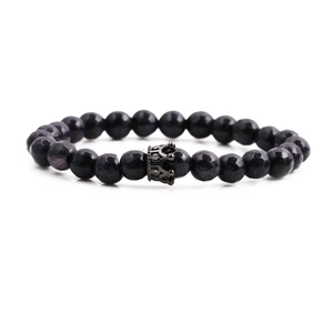 8mm blue sand stone beaded bracelet with black crown charm on white background