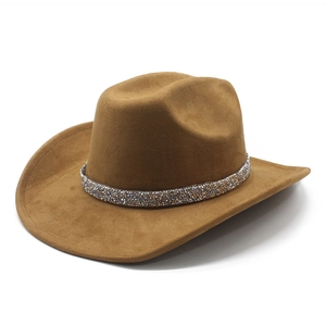 Detail of a brown suede cowboy hat with a sparkling rhinestone decorative band
