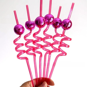 Close-up of pink spiral straws with purple mirrored disco balls for party decorations