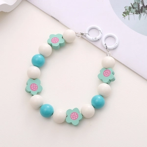 Detail of handmade beaded charm with blue and white beads and green flower accents