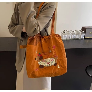 Detail of orange canvas tote bag with dog embroidery and Happy Summer lettering