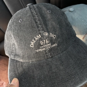 Detailed view of vintage washed canvas baseball cap with white Dream Big embroidery