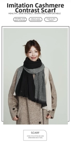 Detail of soft black and grey cashmere-like scarf with fringe trim and color-block design