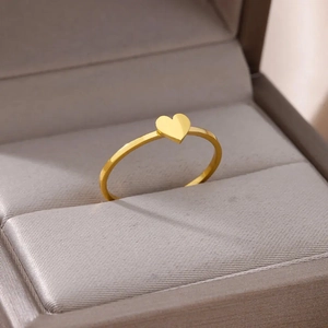 Macro detail of a minimalist gold heart ring displayed in a premium jewelry gift box