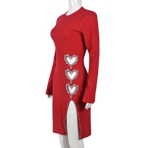 Détail d'une robe moulante rouge avec découpes en cœur latérales et strass brillants