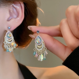 Detailed close-up of golden tassel earrings with multi-color crystals and rhinestones