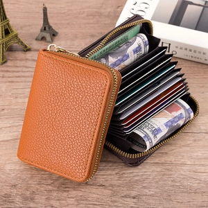 Detail of orange pebble leather card holder showing multi-slot accordion interior