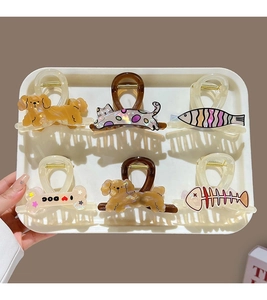 Collection of various acetate hair clips featuring cartoon dogs and fish on a white tray