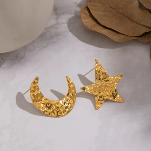 Gros plan de boucles d'oreilles étoile et lune dorées avec une texture martelée élégante