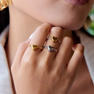 Dreiteiliges Set aus Herz-Anhängern in Gold und Silber, präsentiert am Modell