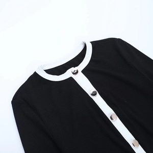 Dettaglio del cardigan in maglia a contrasto con bottoni metallici argentati