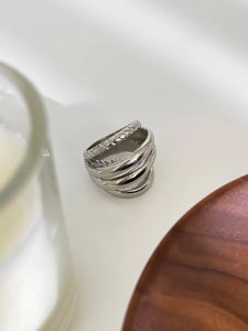 Macro detail of silver multi-layered spiral ring with polished finish and woven texture