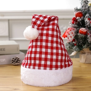 Classic red and white plaid Christmas hat with plush trim on a festive wooden table