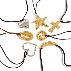 Various stainless steel starfish and heart pendants on black cords over a white background