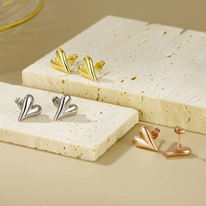 Macro shot of minimalist 18K gold-plated heart earrings in gold, silver, and rose gold