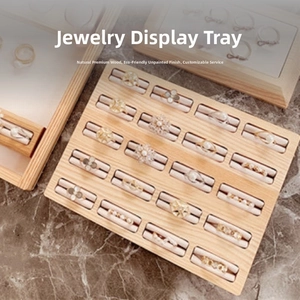 Macro shot of natural walnut ring display tray with multiple slots on marble surface