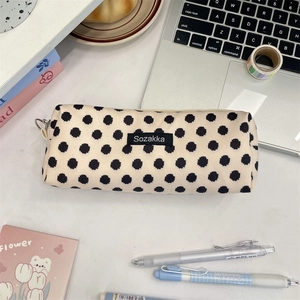 Detail view of a floral canvas pencil case on a desk with stationery items